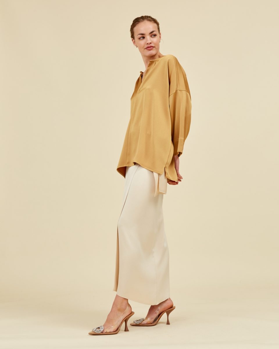 https://www.seamehappy.be/wp-content/uploads/2025/07/Sea-Me-Happy-Charly-blouse-gold-Hailey-skirt-ivory-side-1684-960x1200.jpg