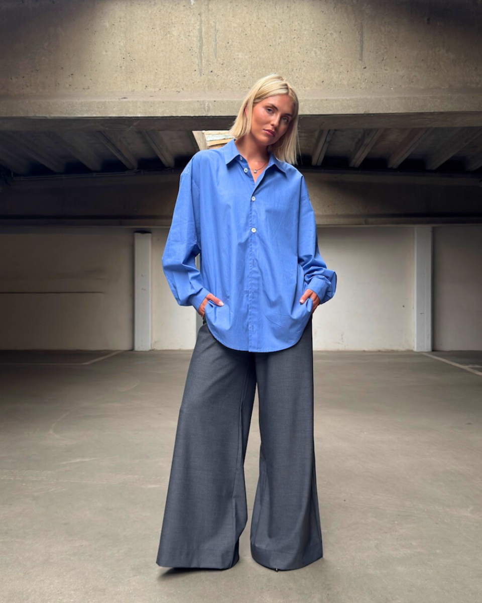 https://www.seamehappy.be/wp-content/uploads/2025/08/Sea-Me-Happy-HArvey-Shirt-Light-Cotton-blue-Super-Woody-Pants-Melange-Dark-grey-front-9726-960x1200.png